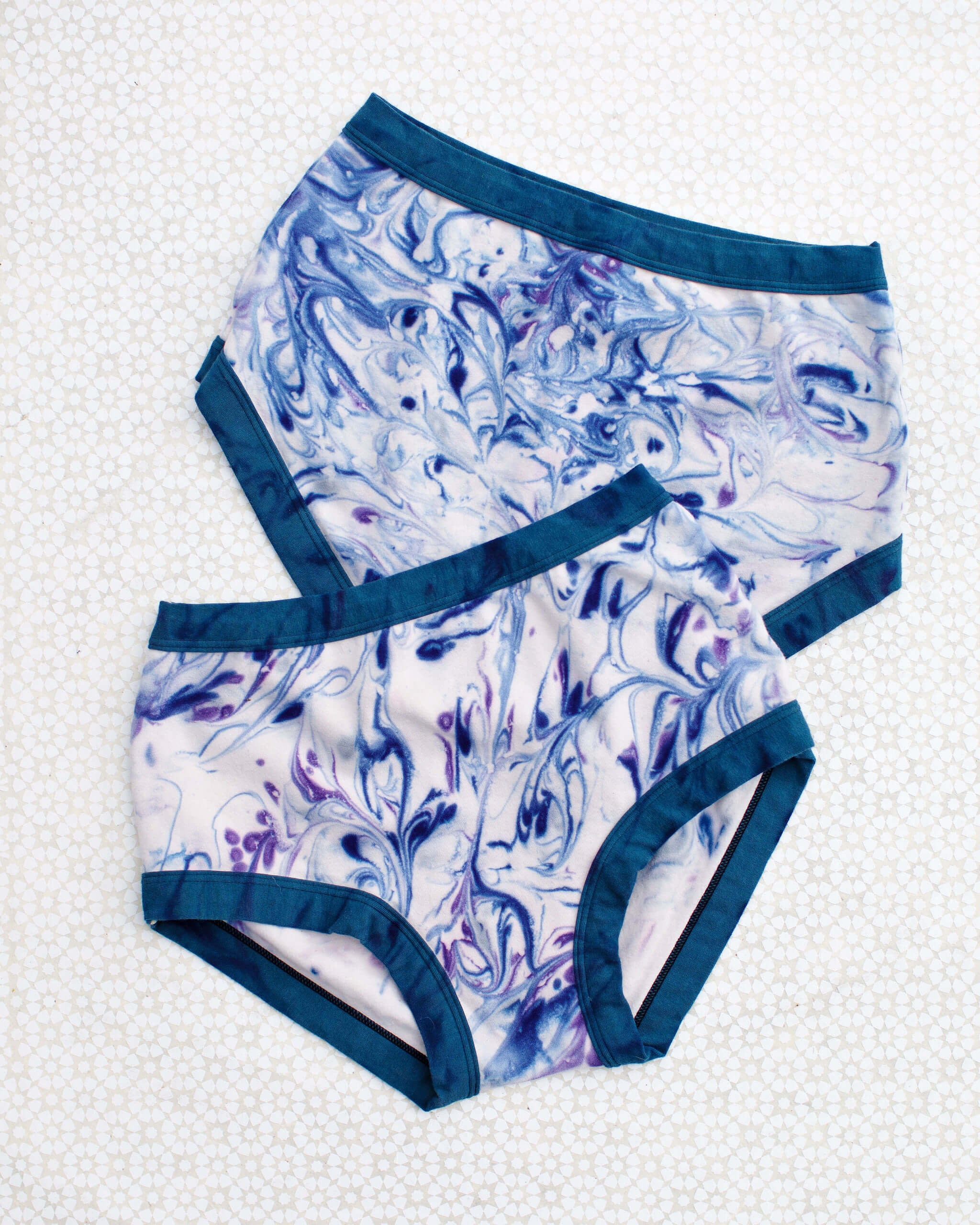 Flat lay of Thunderpants Original style underwear in Winter Blues Marble dye - different blues and purples swirled to look like marble. 