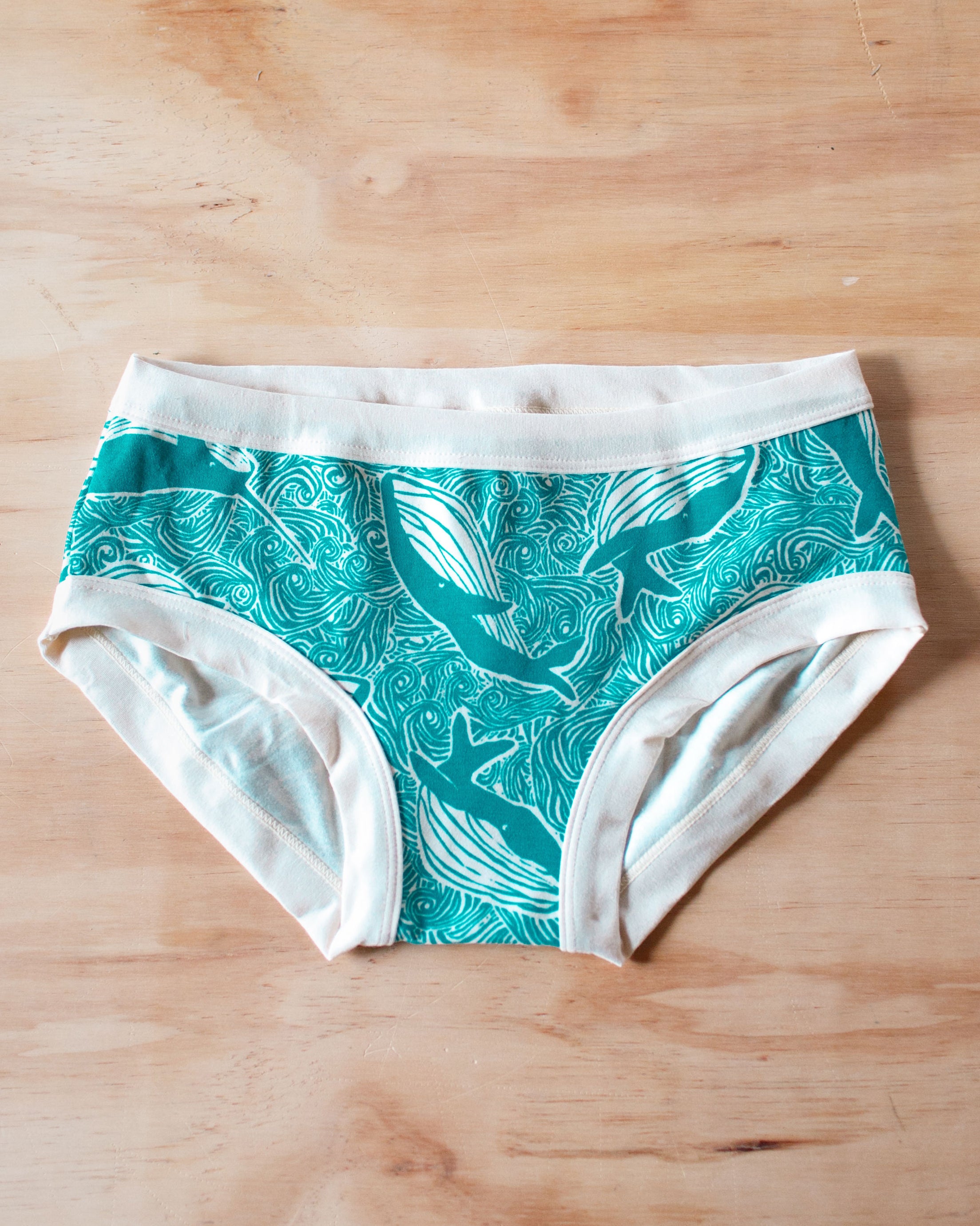 Flat lay of Thunderpanst organic cotton Hipster style underwear in our Marine Whales print: turquoise all-over whale and ocean print.
