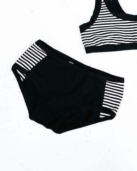Flat lay of Thunderpants organic cotton Hipster Panel Pants underwear with plain black center and black and white stripe sides.