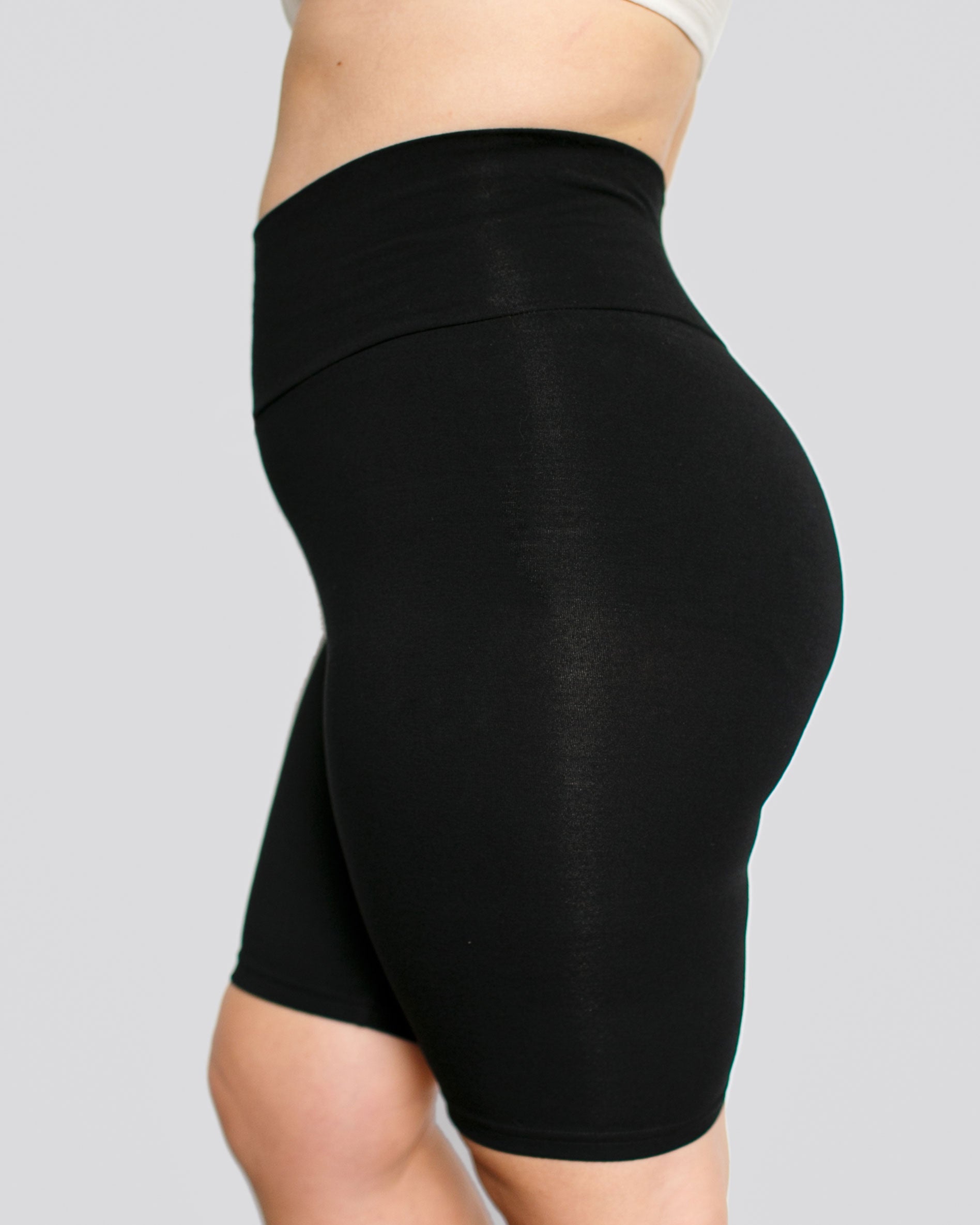 Side view of model wearing Thunderpants organic cotton High Rise Bike Shorts in plain Black color.