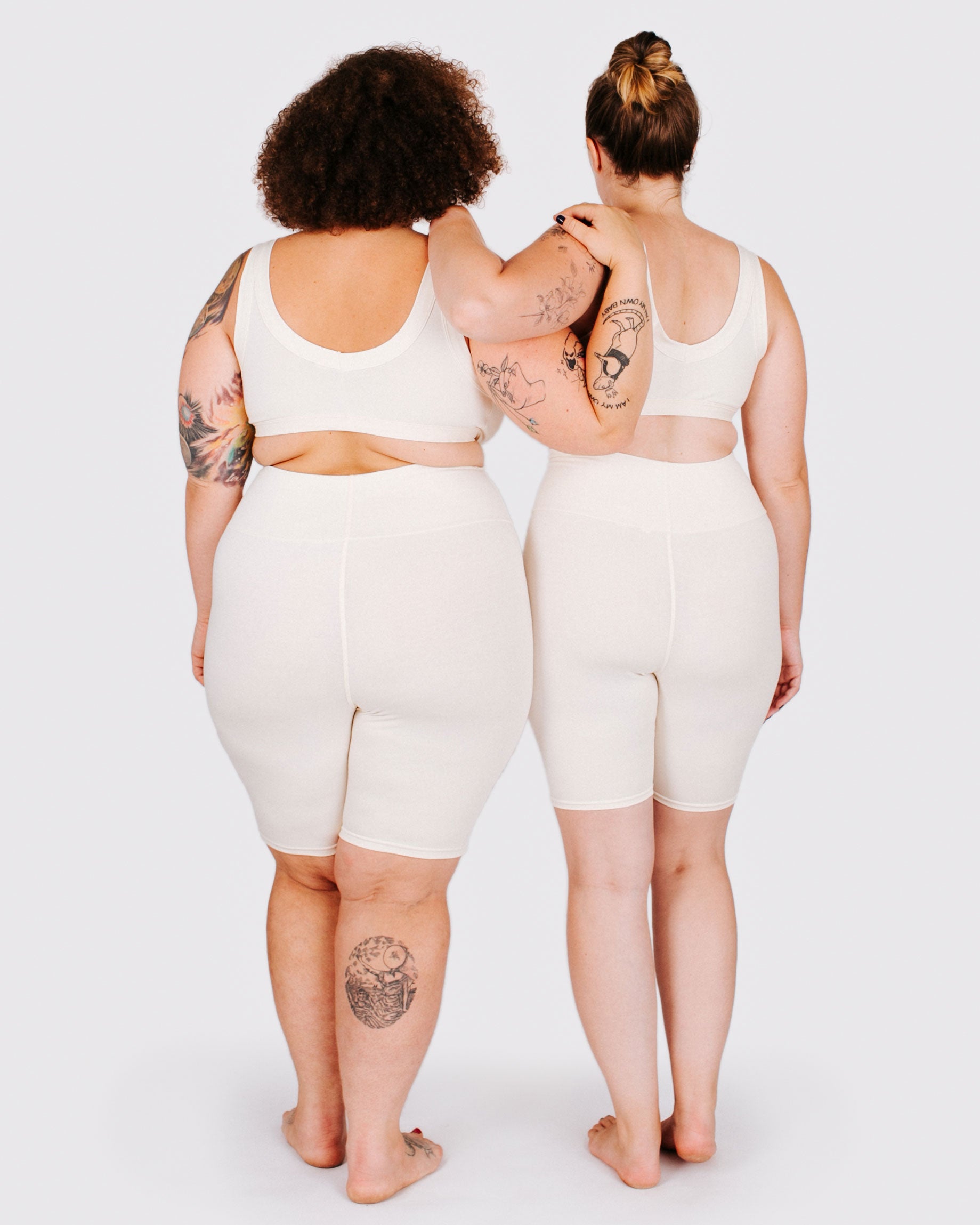 Fit photo from the back of Thunderpants organic cotton Bike Shorts and Bralettes in off-white on two models standing together.