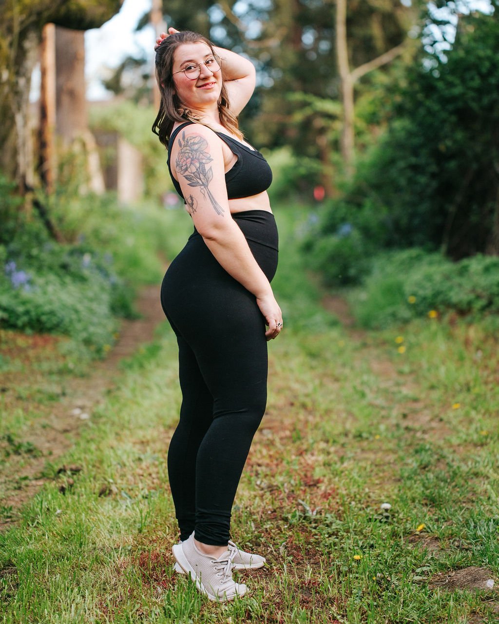 Woman standing in greenery wearing Thunderpants organic cotton High Rise Extra Long Length Leggings and Bralette in plain black.