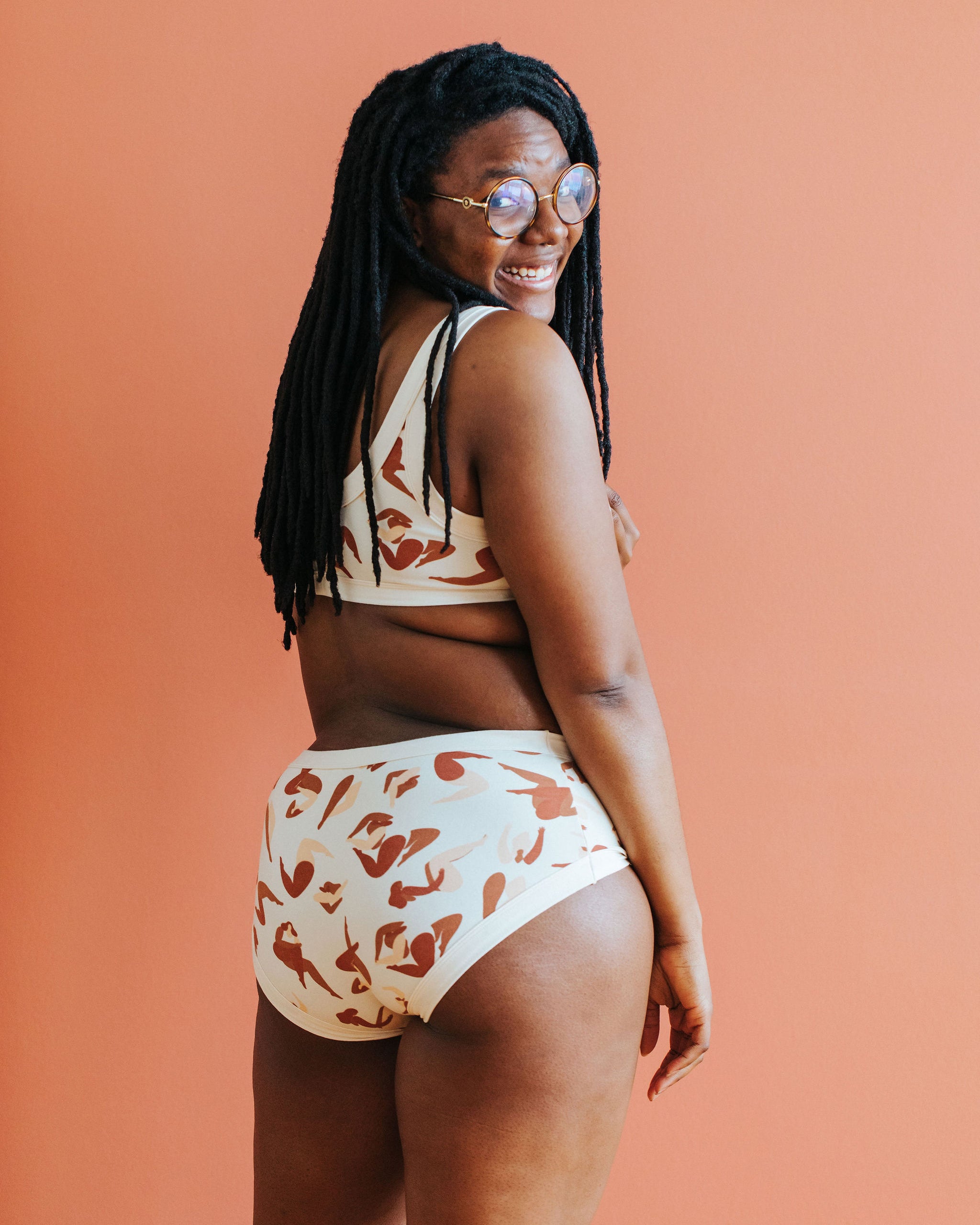 Model with their back to the camera wearing Thunderpants Hipster style underwear and Bralette in Bodies in Motion: women in different shades of browns and tans.