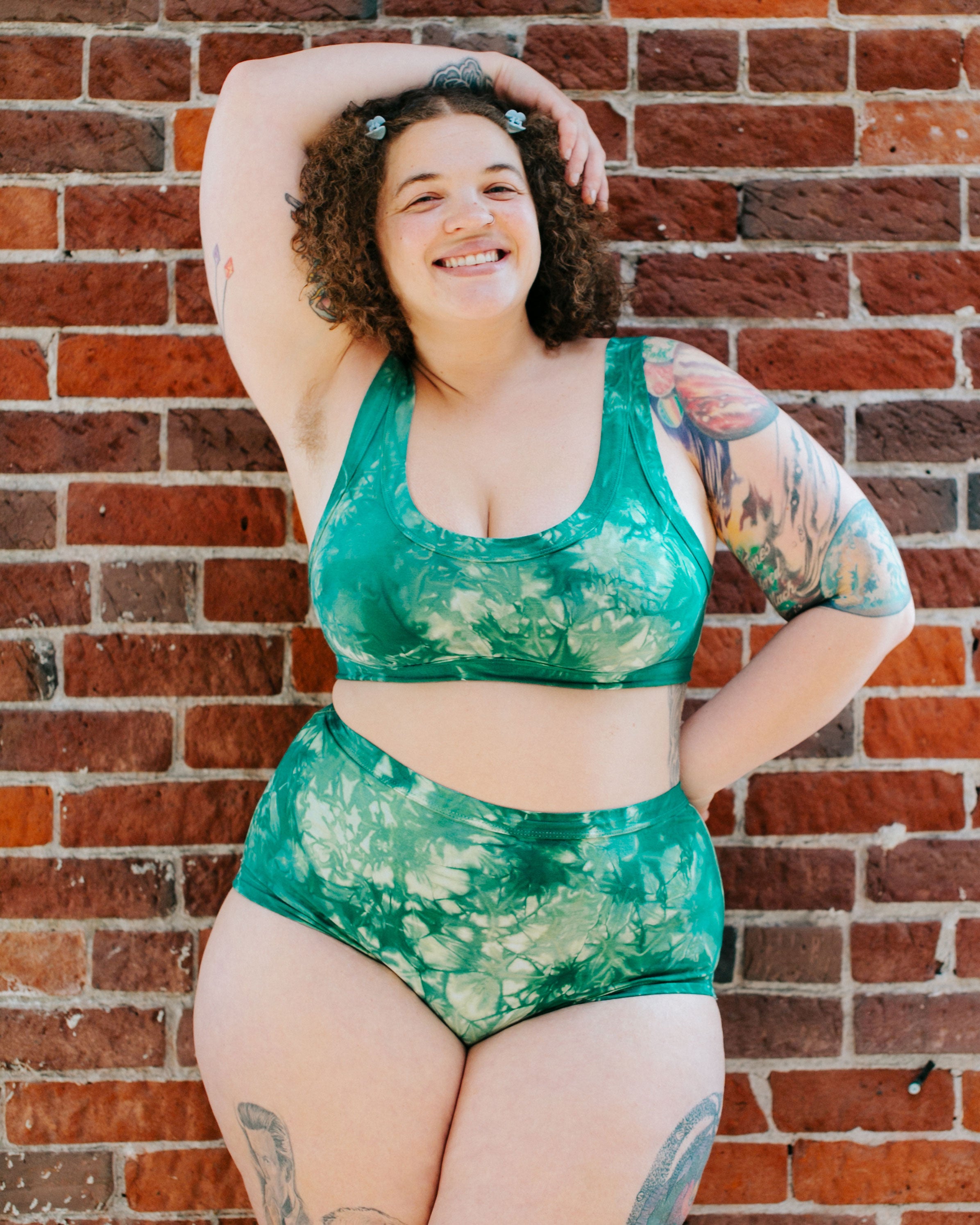 Model smiling wearing Thunderpants organic cotton Original style underwear and Bralette in Clover Green scrunch dye.