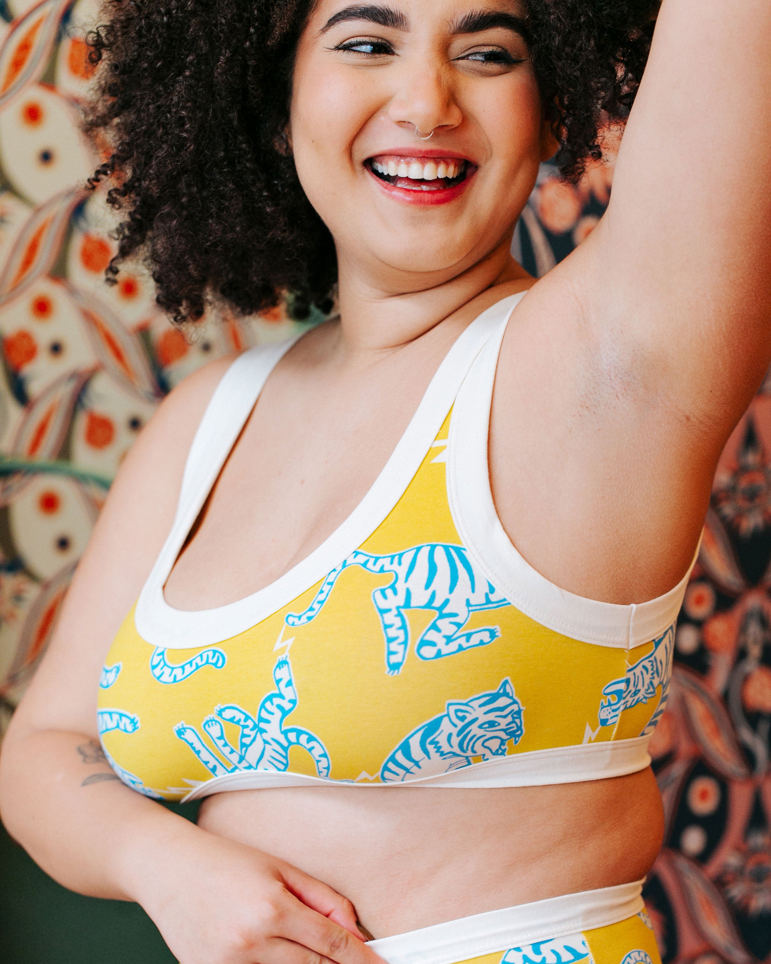 Close up of model wearing Thunderpants organic cotton Bralette in Easy Tiger - chartreuse with blue and white tigers.
