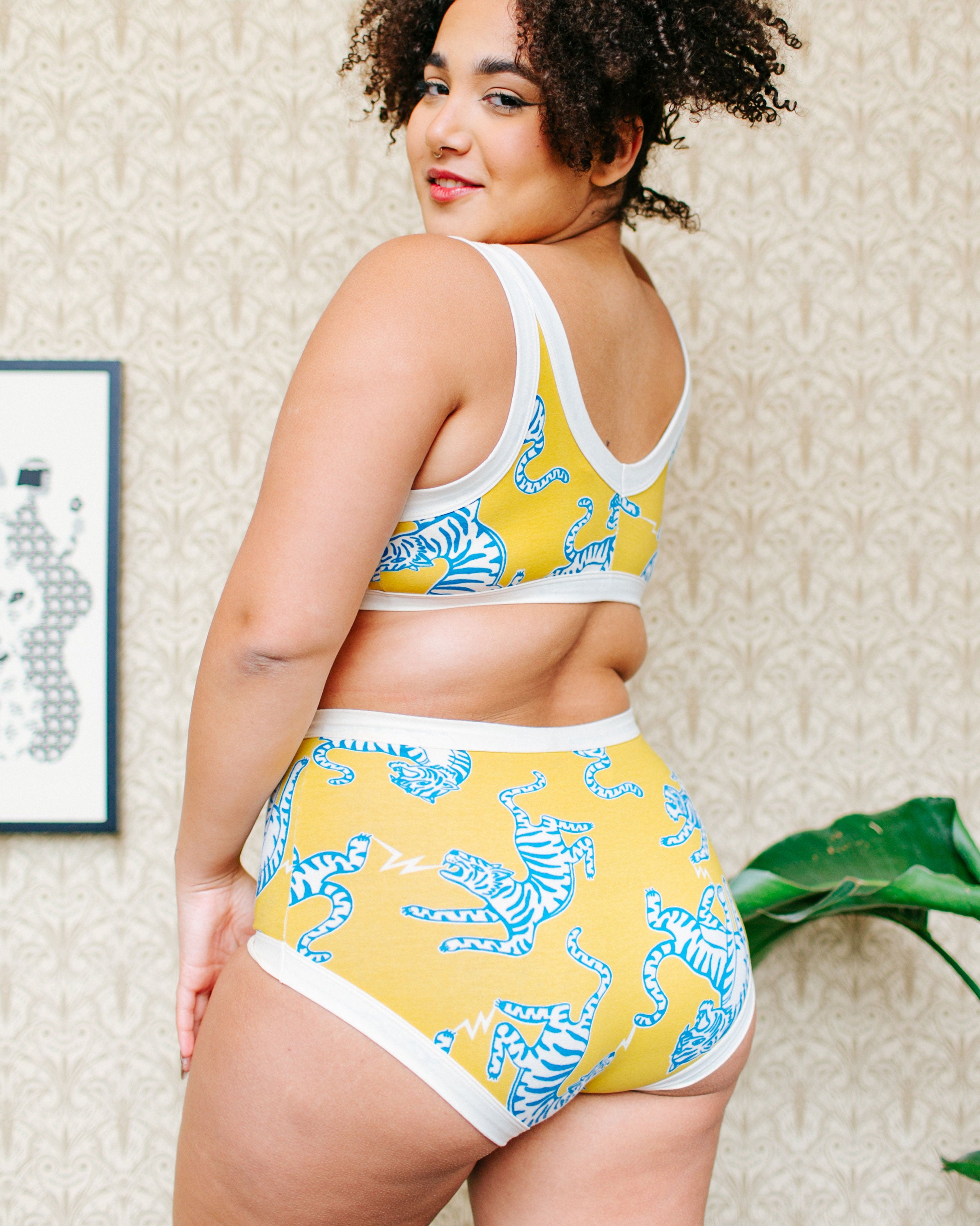 Back of model wearing Thunderpants organic cotton Original style underwear and Bralette in Easy Tiger - chartreuse with blue and white tigers.
