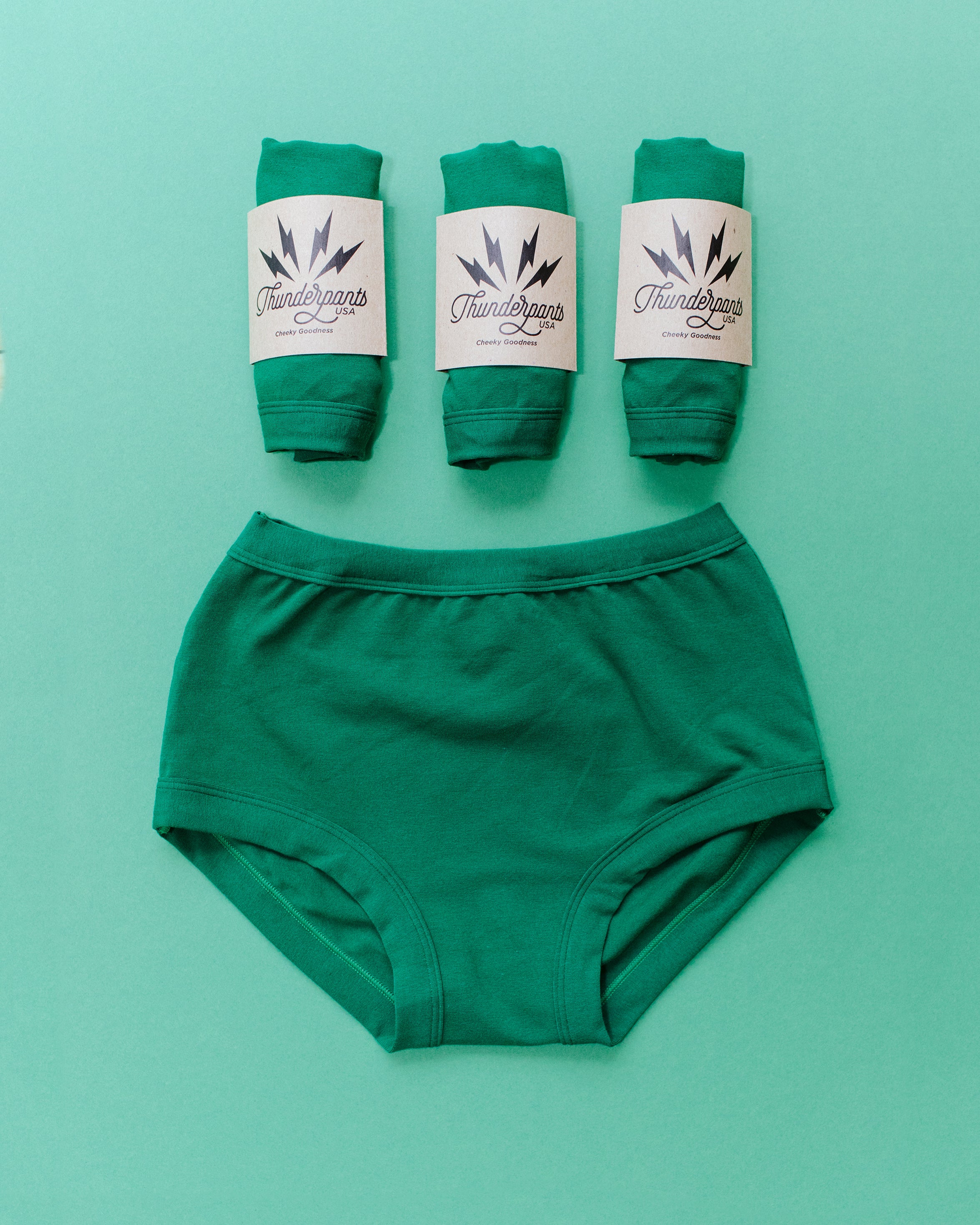 Flat lay of Thunderpants Original style underwear and three packaged undies in Emerald Green.