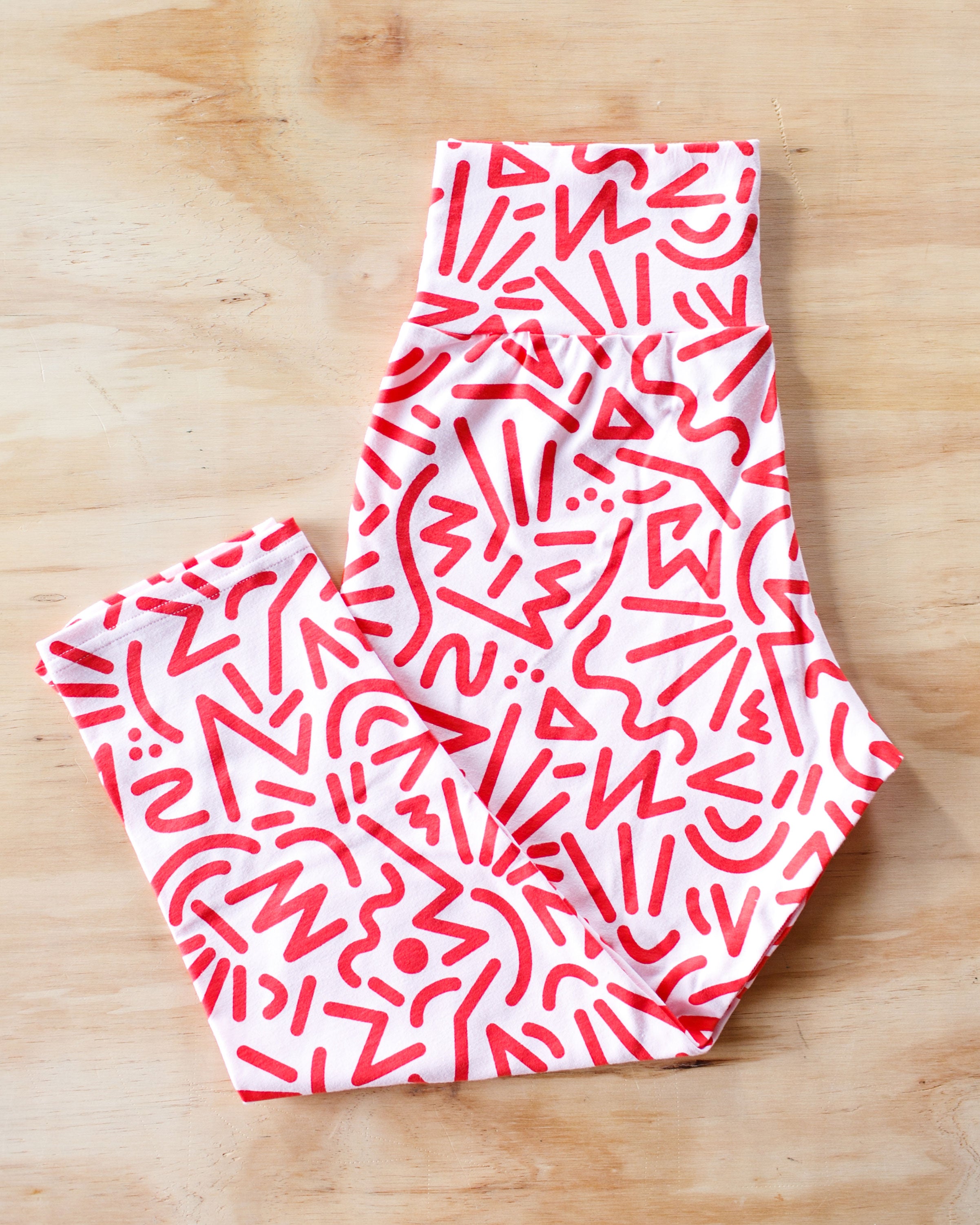 Flat lay of Thunderpants organic cotton 3/4 Leggings in our Energy Vibes print: Perfect Pink with dark pink squiggles.