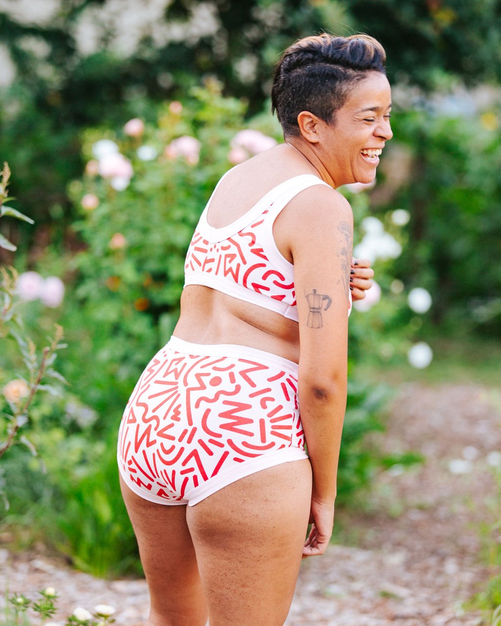 model smiling wearing Thunderpants Organic Cotton Original style underwear in our Energy Vibes print: prink with large red squggiles.