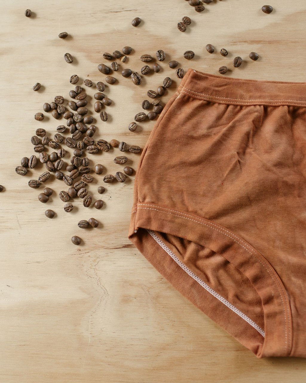 Flat lay of Thunderpants Organic Cotton Original underwear in hand dyed Shiitake color with Espresso coffee beans around.