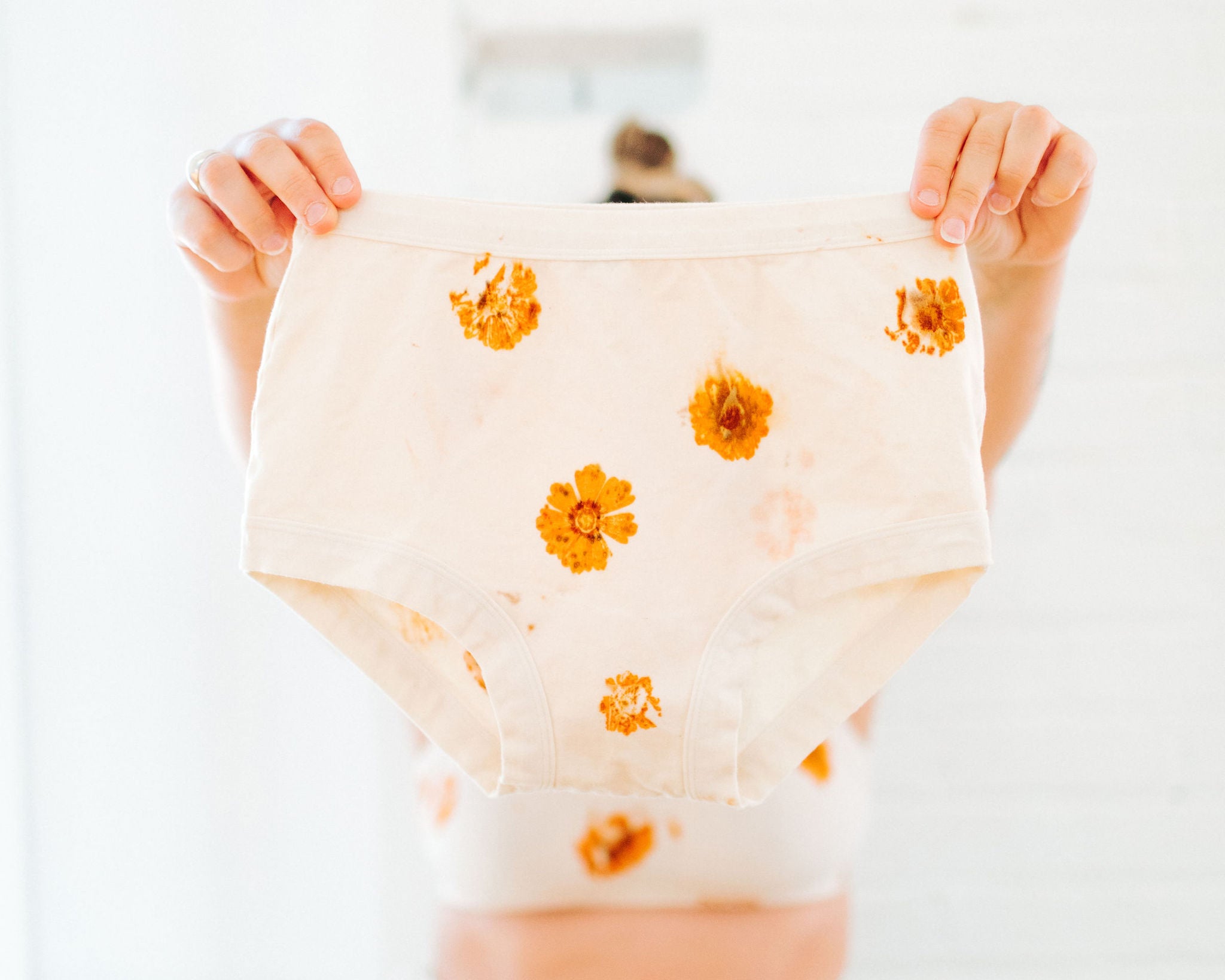 Person holding Thunderpants Original style underwear in the Limited Edition Flower Press Botanical Dye - flowers pressed on the underwear fabric to create a print.