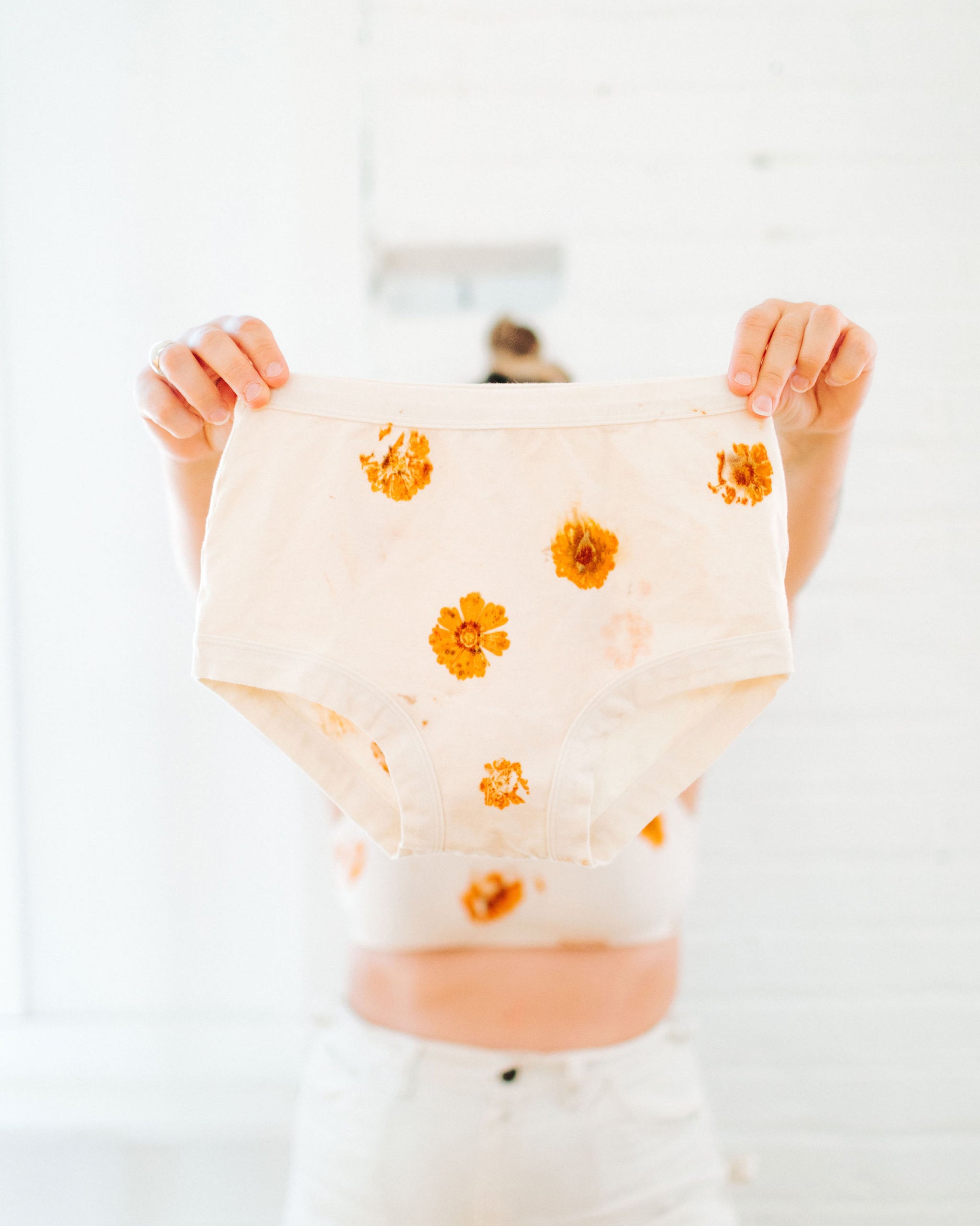 Person holding Thunderpants Original style underwear in the Limited Edition Flower Press Botanical Dye - flowers pressed on the underwear fabric to create a print.
