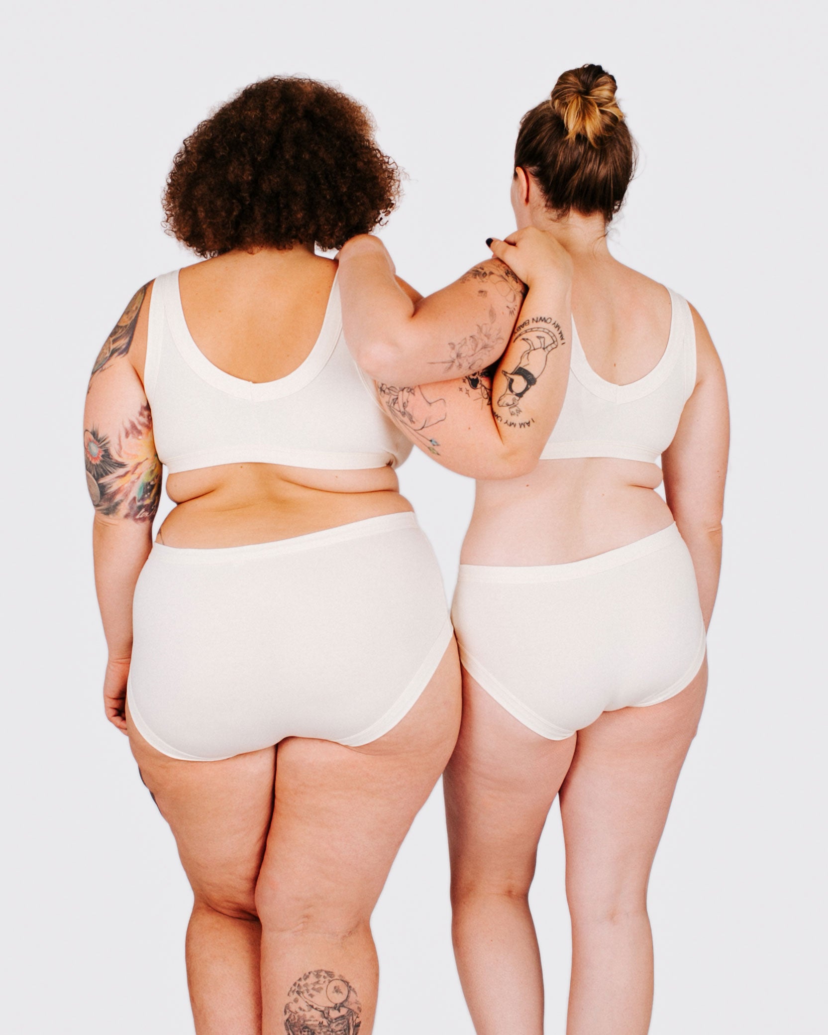 Fit photo from the back of Thunderpants organic cotton Hipster style underwear and Bralette in off-white on two models standing together.