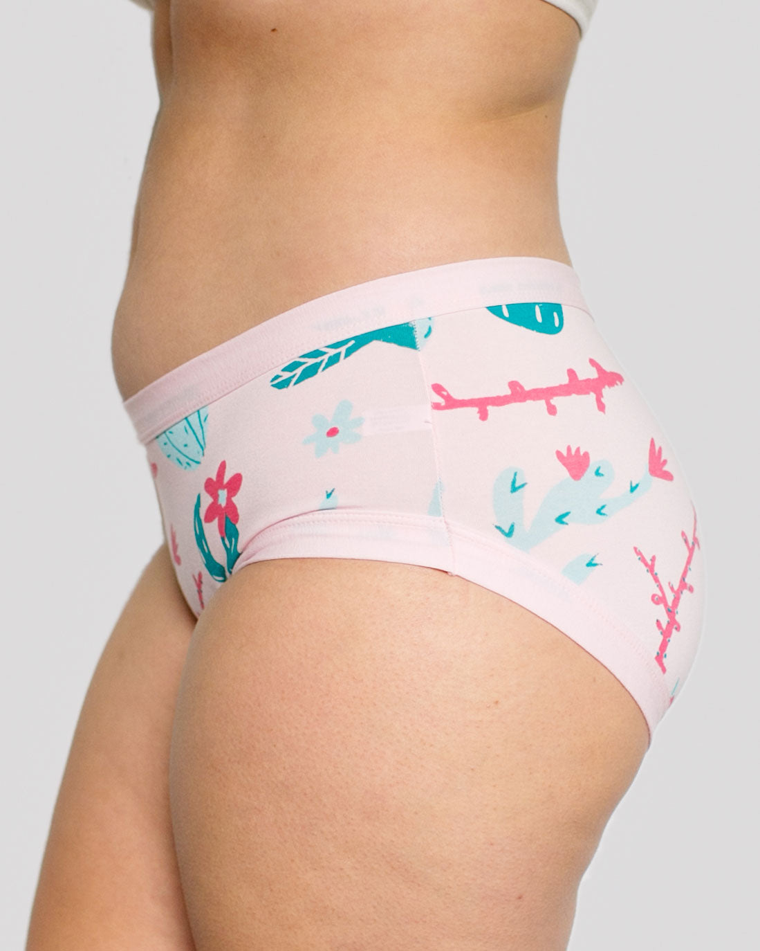 Side of model wearing Thunderpants organic cotton Hipster style underwear in Prickly Cactus print: Perfect Pink with green and pink cacti.