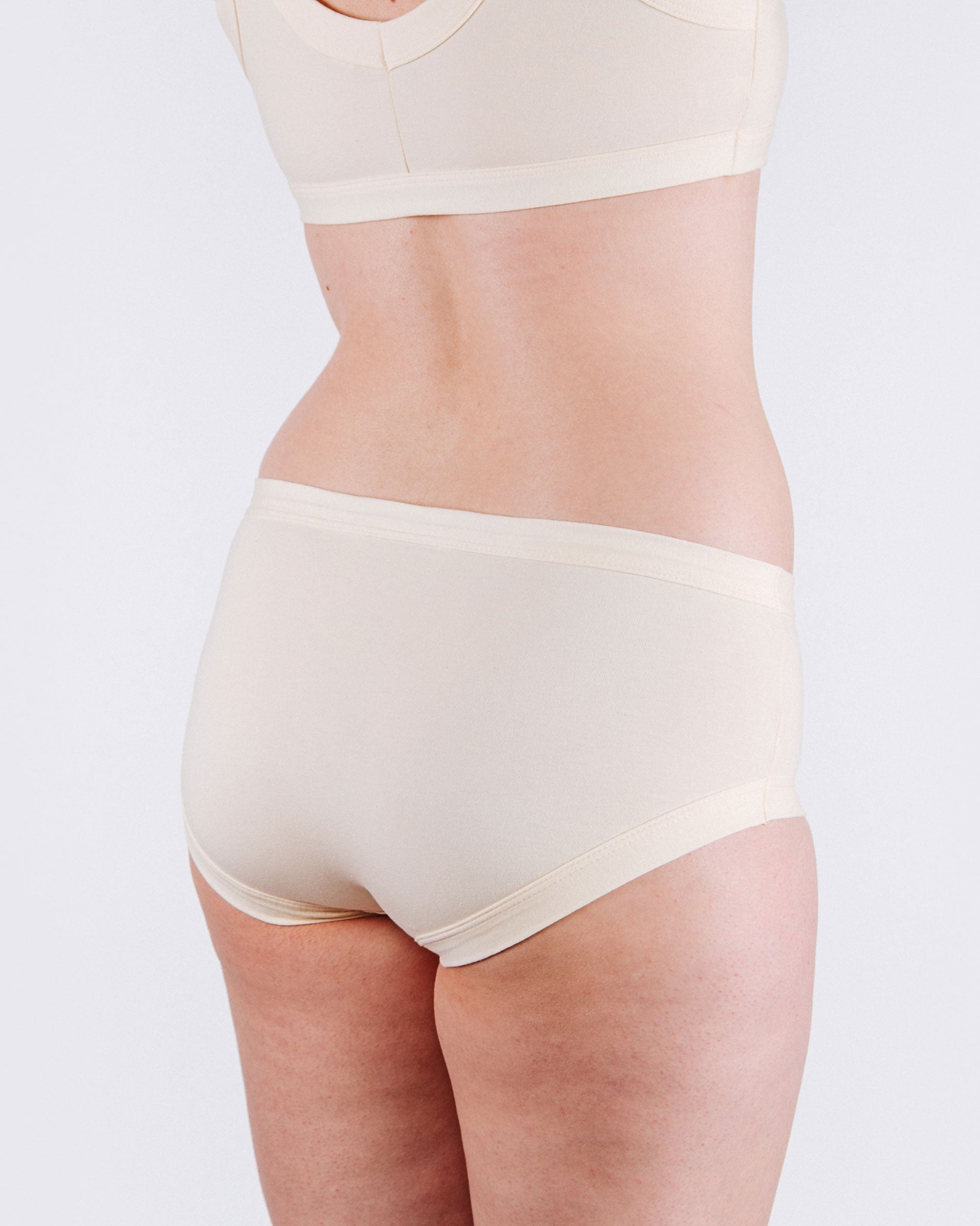 Fit photo from the back of Thunderpants organic cotton Hipster style underwear in off-white vanilla, showing a wedgie-free bum, on a model.