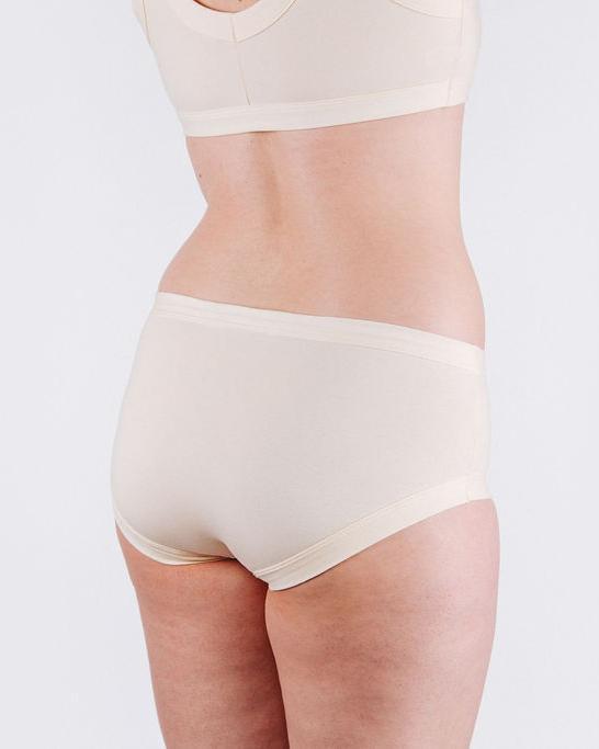 Fit photo from the back of Thunderpants organic cotton Women’s Hipster style underwear in off-white vanilla, showing a wedgie-free bum, on a woman.