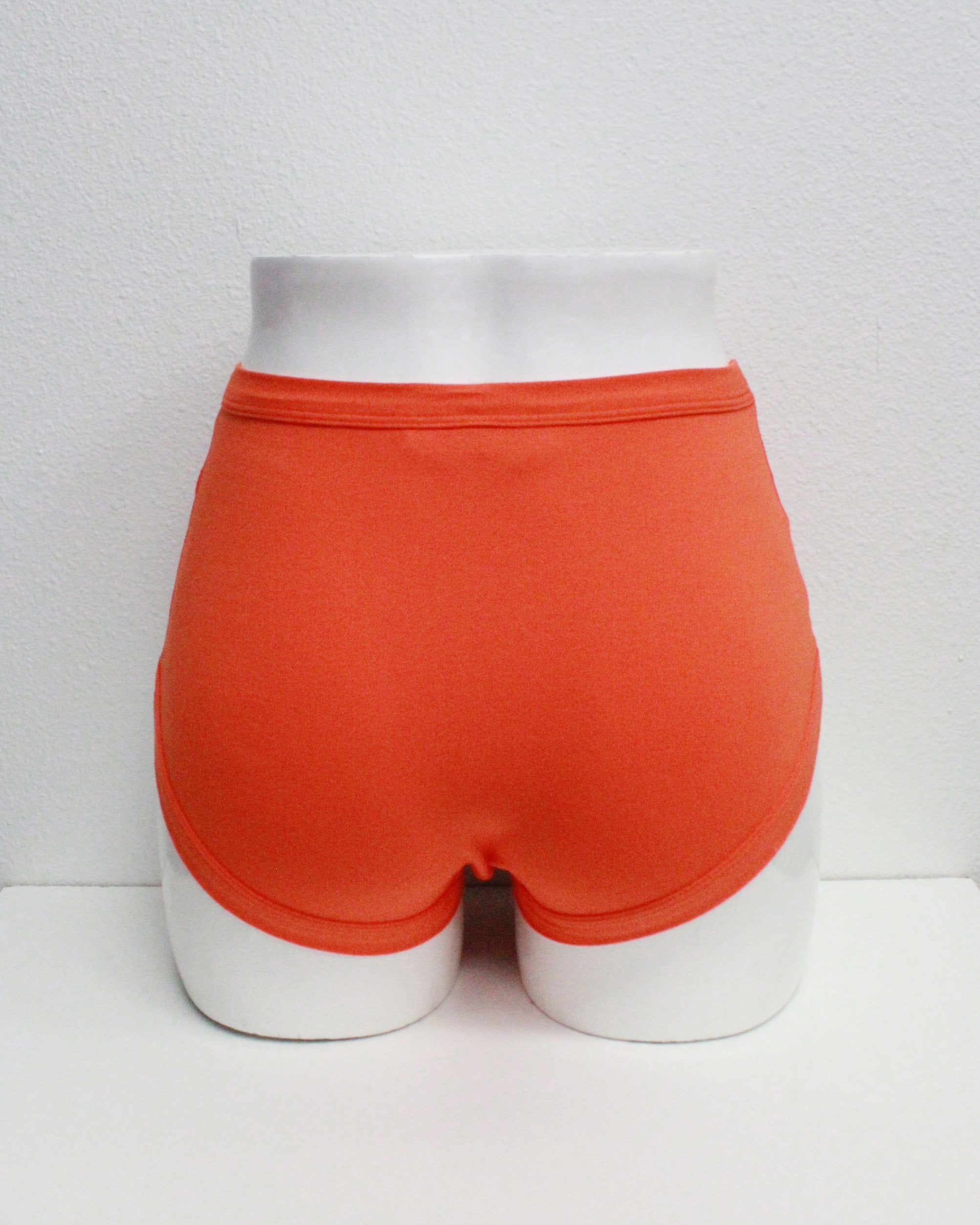Back of Thunderpants organic cotton Original Panel Pant style underwear in plain tangerine orange shown on mannequin bum and legs.
