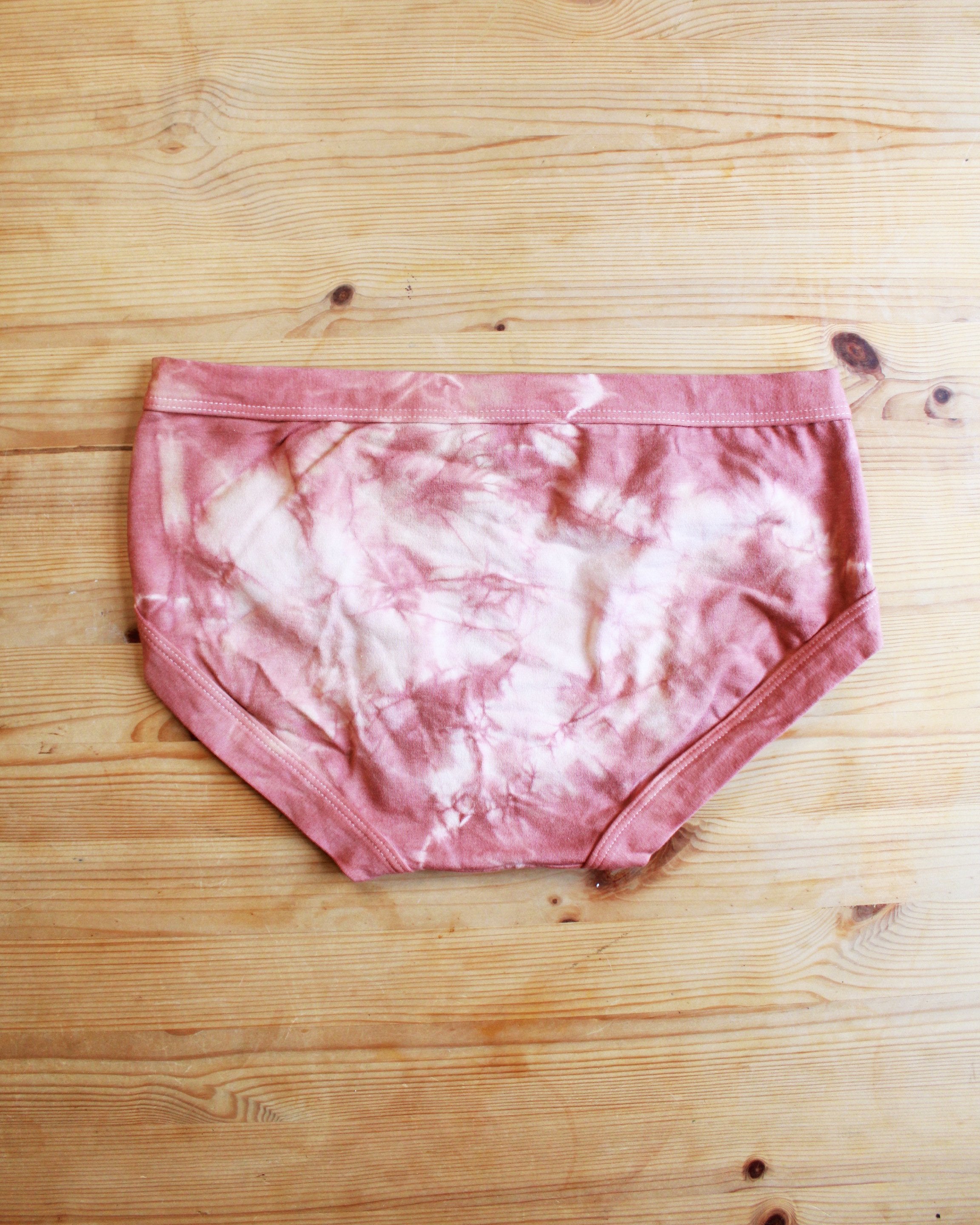 Flat lay back of Thunderpants organic cotton Women’s Hipster style underwear in limited edition hand dye pink tie dye.
