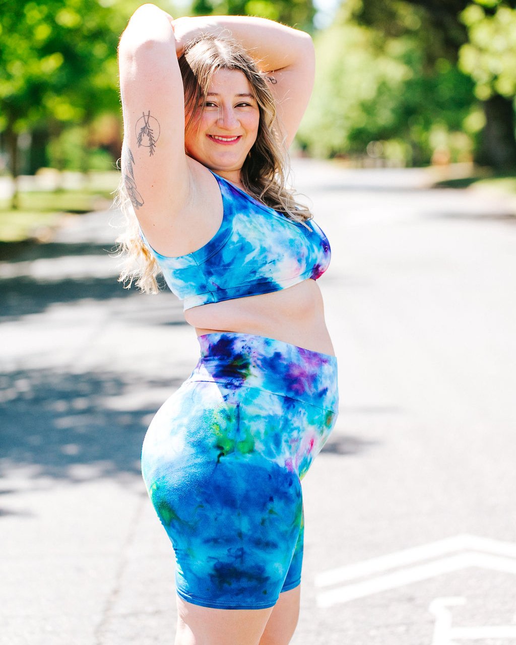 Close up of model wearing Thunderpants organic cotton High Rise Bike Shorts and Bralette in hand dye Ice Dye multicolored tie-dye.