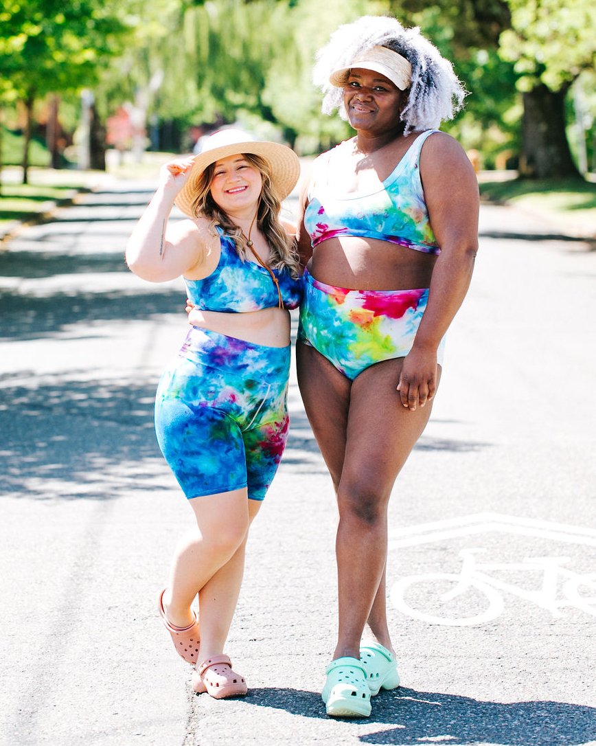 Two models smiling together wearing Thunderpants Organic Cotton Original style underwear and Bralettes in our hand dye Ice Dye multicolored tie-dye.