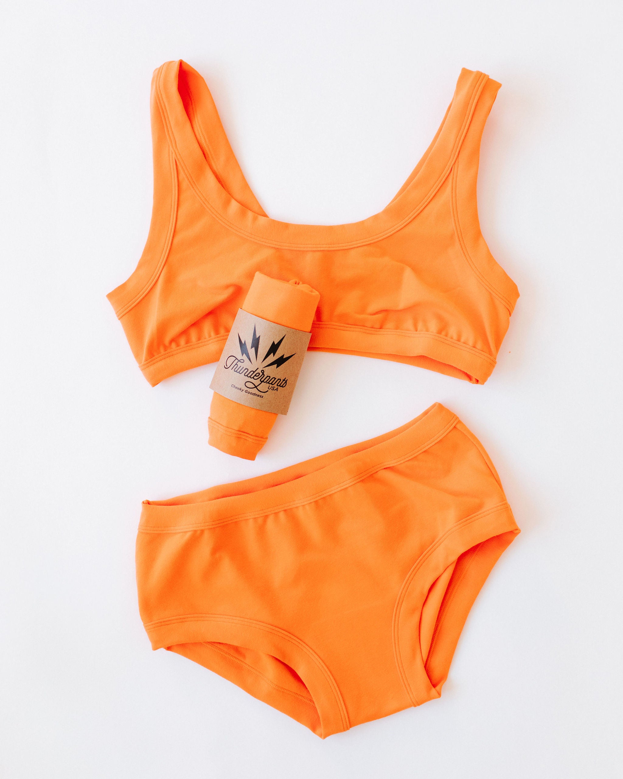 Flat lat of Thunderpants Original style underwear and Bralette in Oregon Sunstone orange color. 
