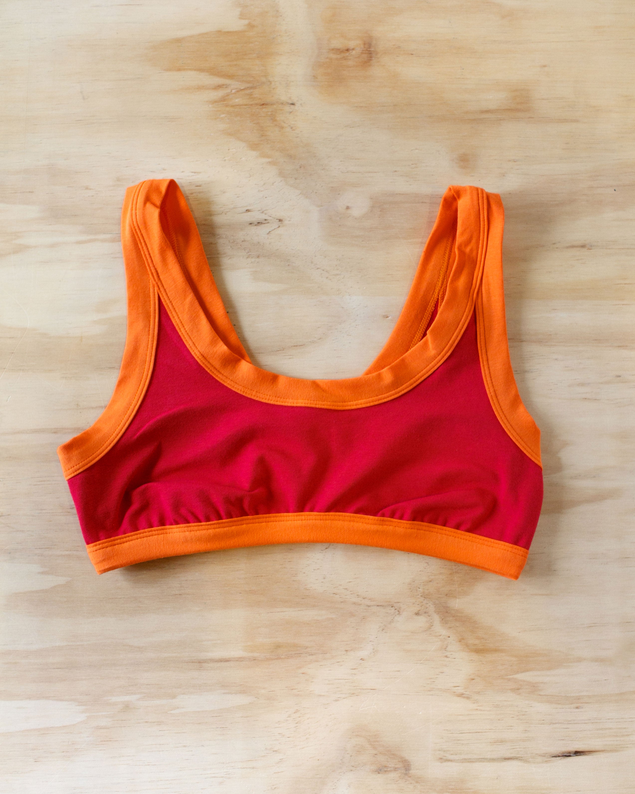 Flat lay of Bralette in Pants on Fire: red with orange binding.