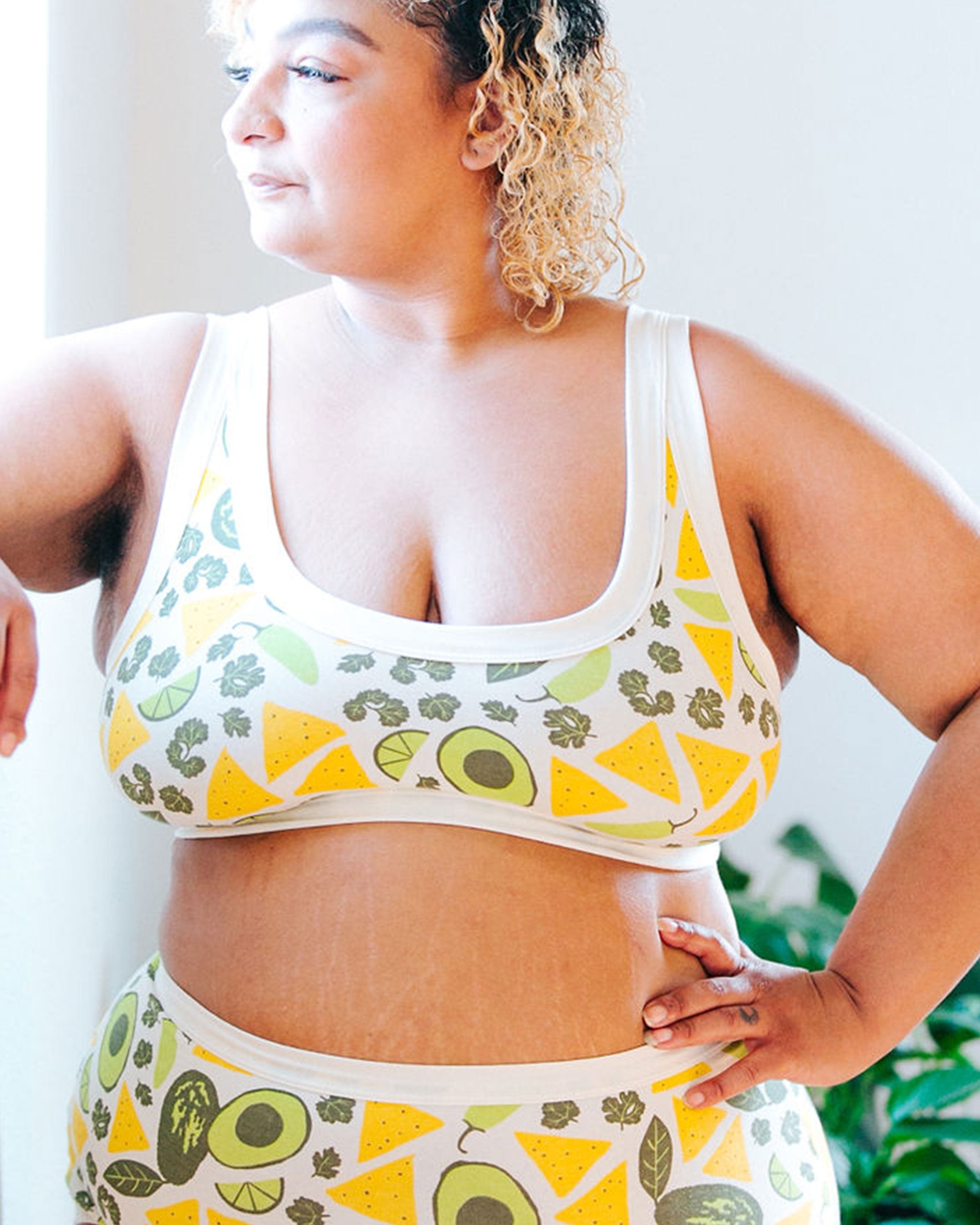 Close up of a beautiful plus-sized model wearing a Thunderpants organic cotton Bralette and Original style underwear in a deconstructed guacamole (avocado, cilantro, pepper, lime, and tortilla chip) print.