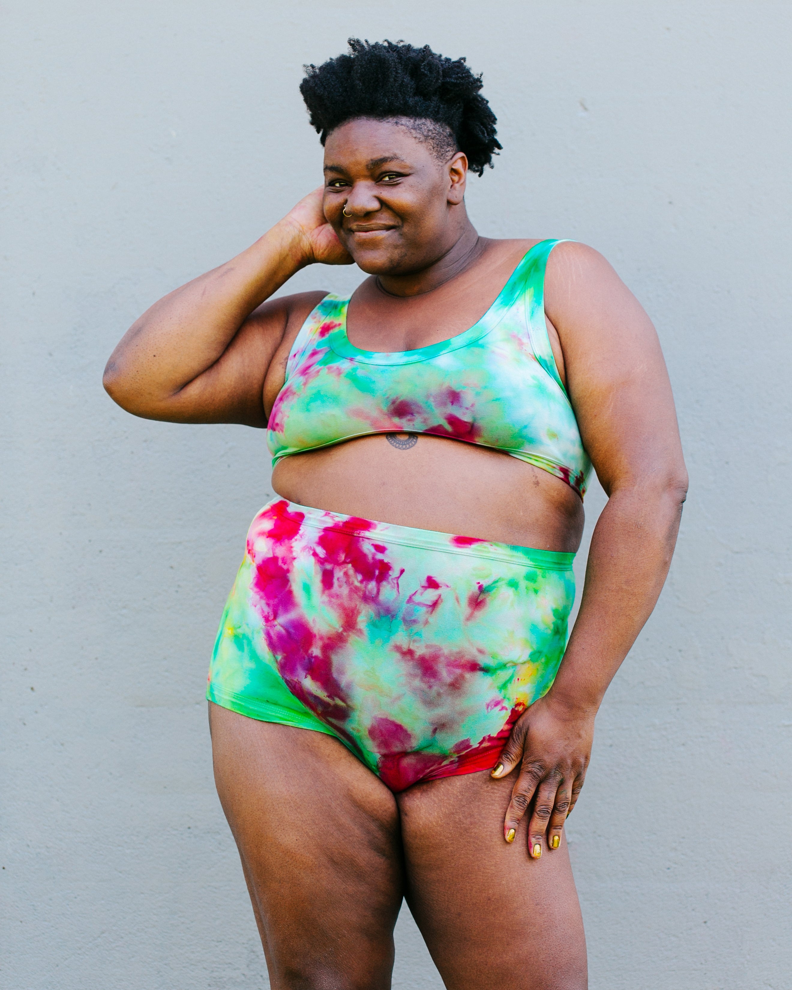 Model wearing a set of Ice Dyed Sky Rise style underwear and Bralette in a mix of green, pink, and yellow colors.