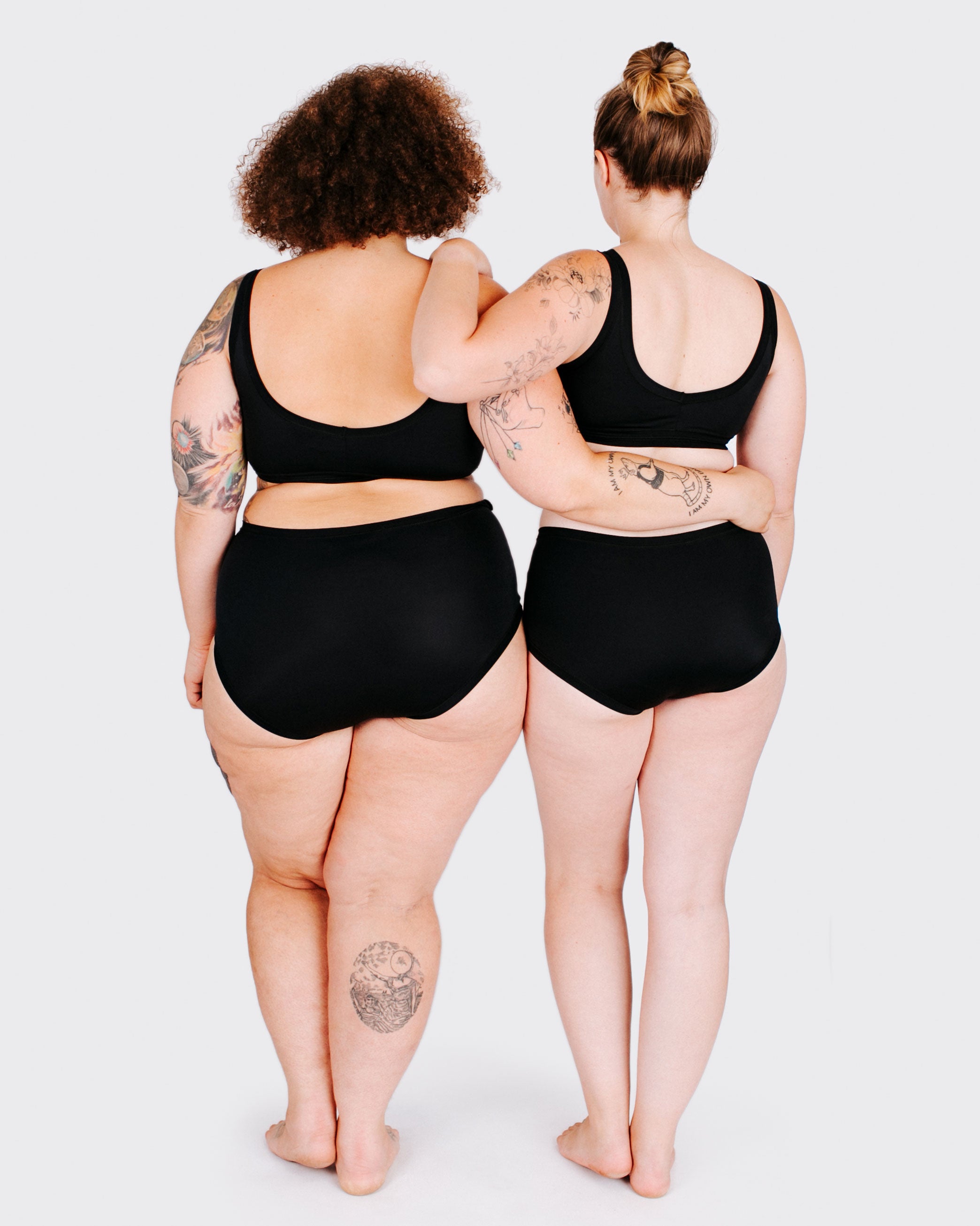 Fit photo from the back of Thunderpants recycled nylon Swimwear Original style bottoms and Swimwear Top in Plain Black on two models standing together.