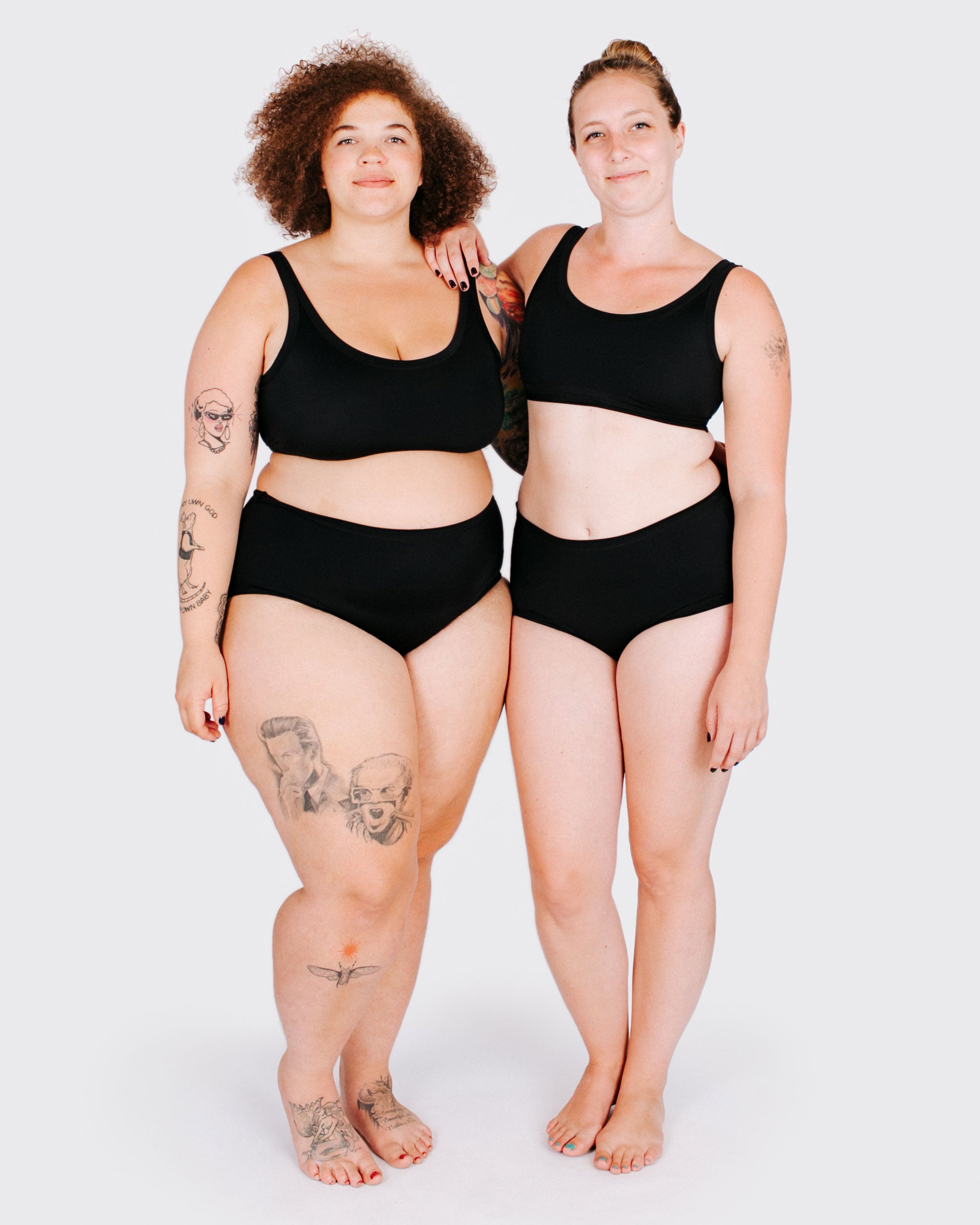 Fit photo from the front of Thunderpants recycled nylon Swimwear Original style bottoms and Swimwear Top in Plain Black on two models standing together.