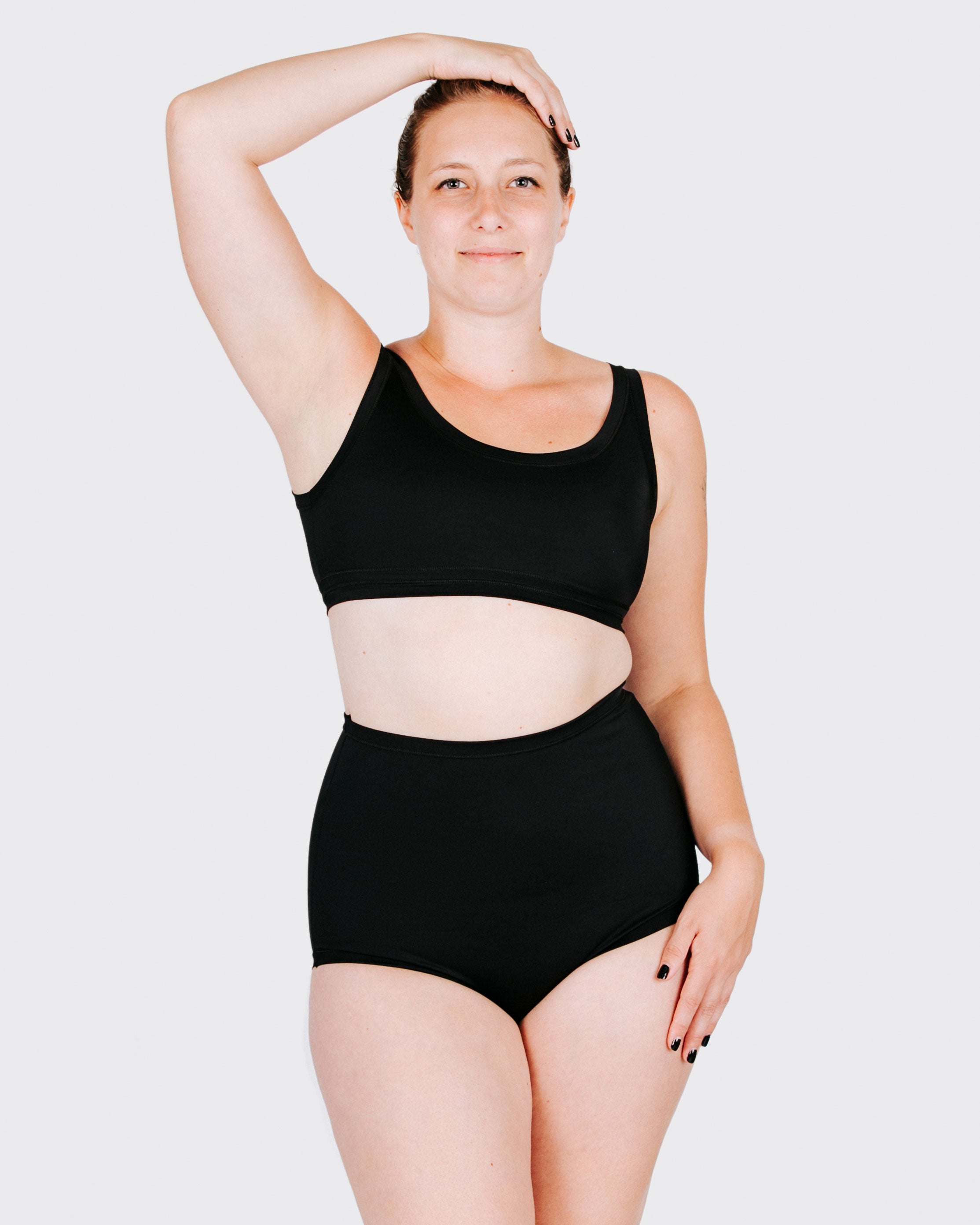 Fit photo from the front of Thunderpants recycled nylon Swimwear Sky Rise style bottoms in Plain Black on a model.