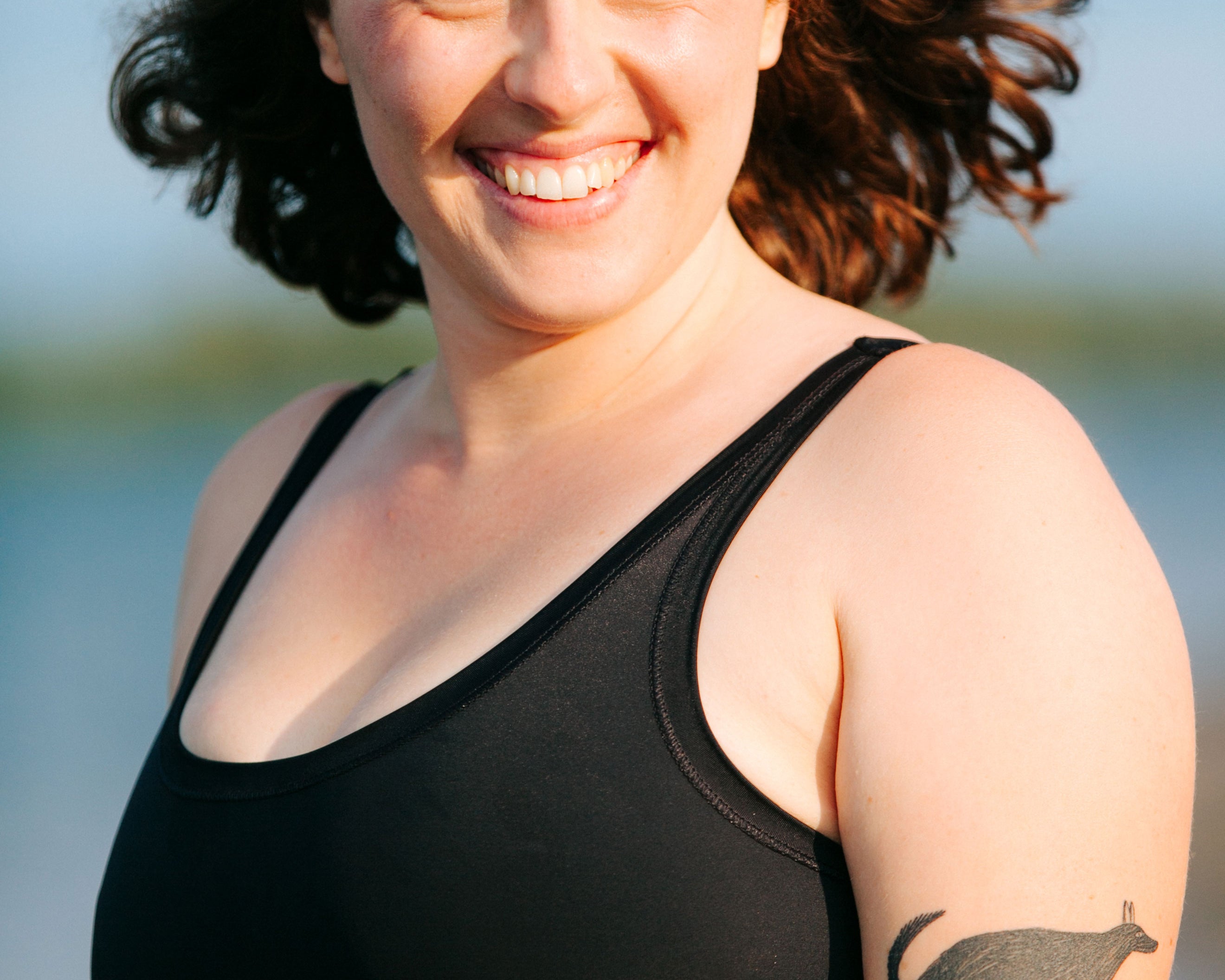Close-up of model wearing Thunderpants recycled nylon Swimwear Top in Plain Black.