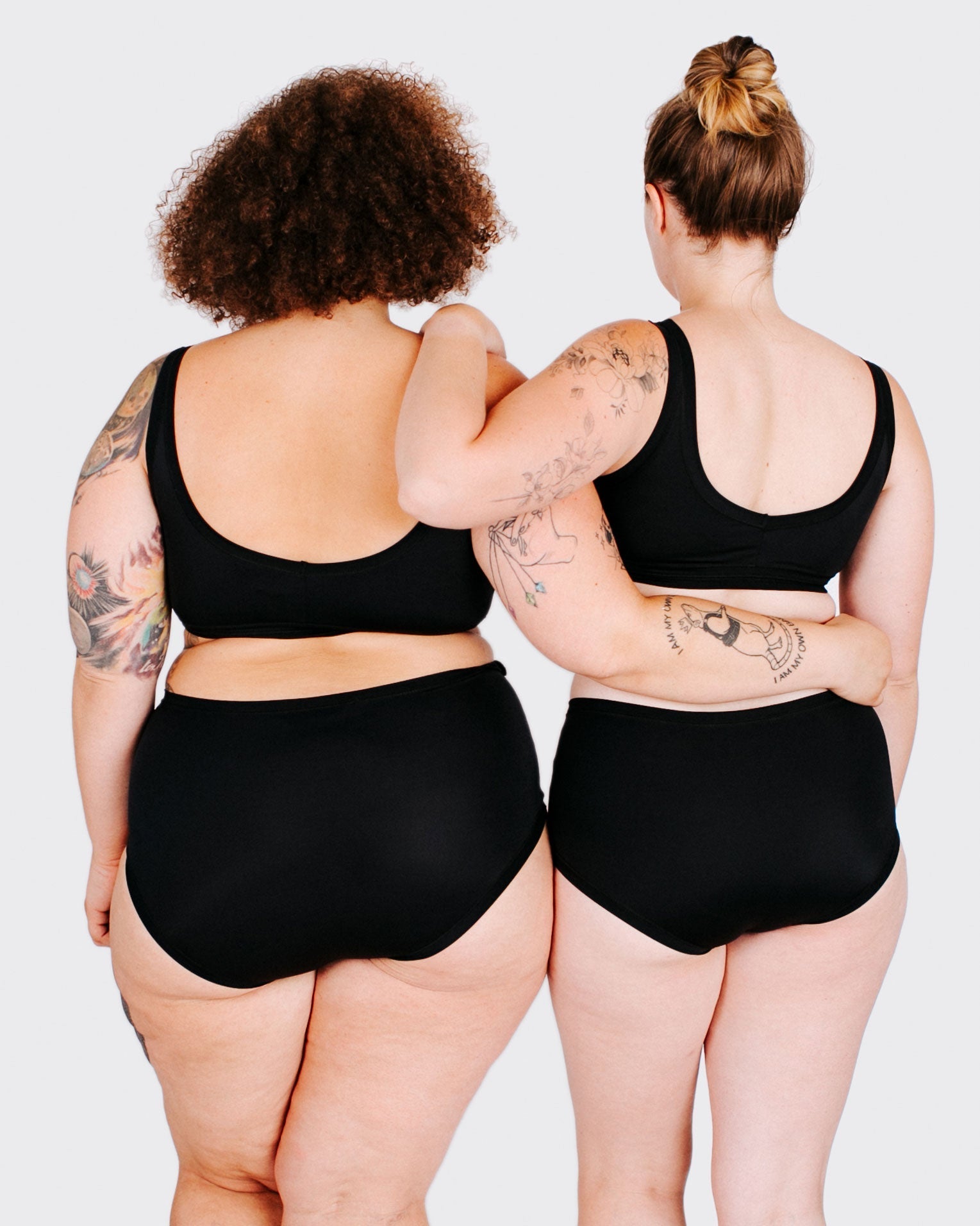 Fit photo from the back of Thunderpants recycled nylon Swimwear Top and Swimwear Original style bottoms in Plain Black on two models standing together.