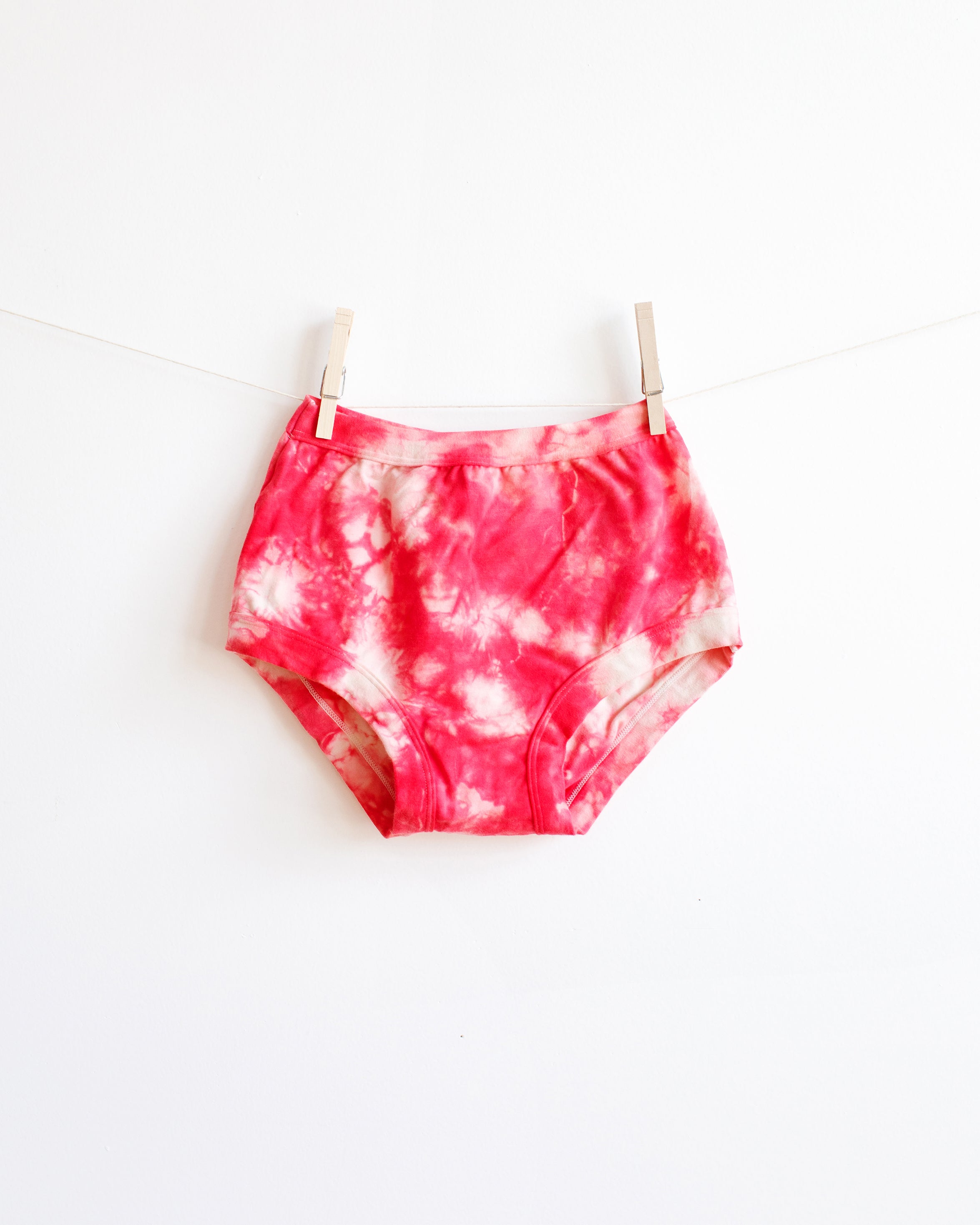 Hanging Thunderpants Original style underwear with red and white scrunch dye on white background.