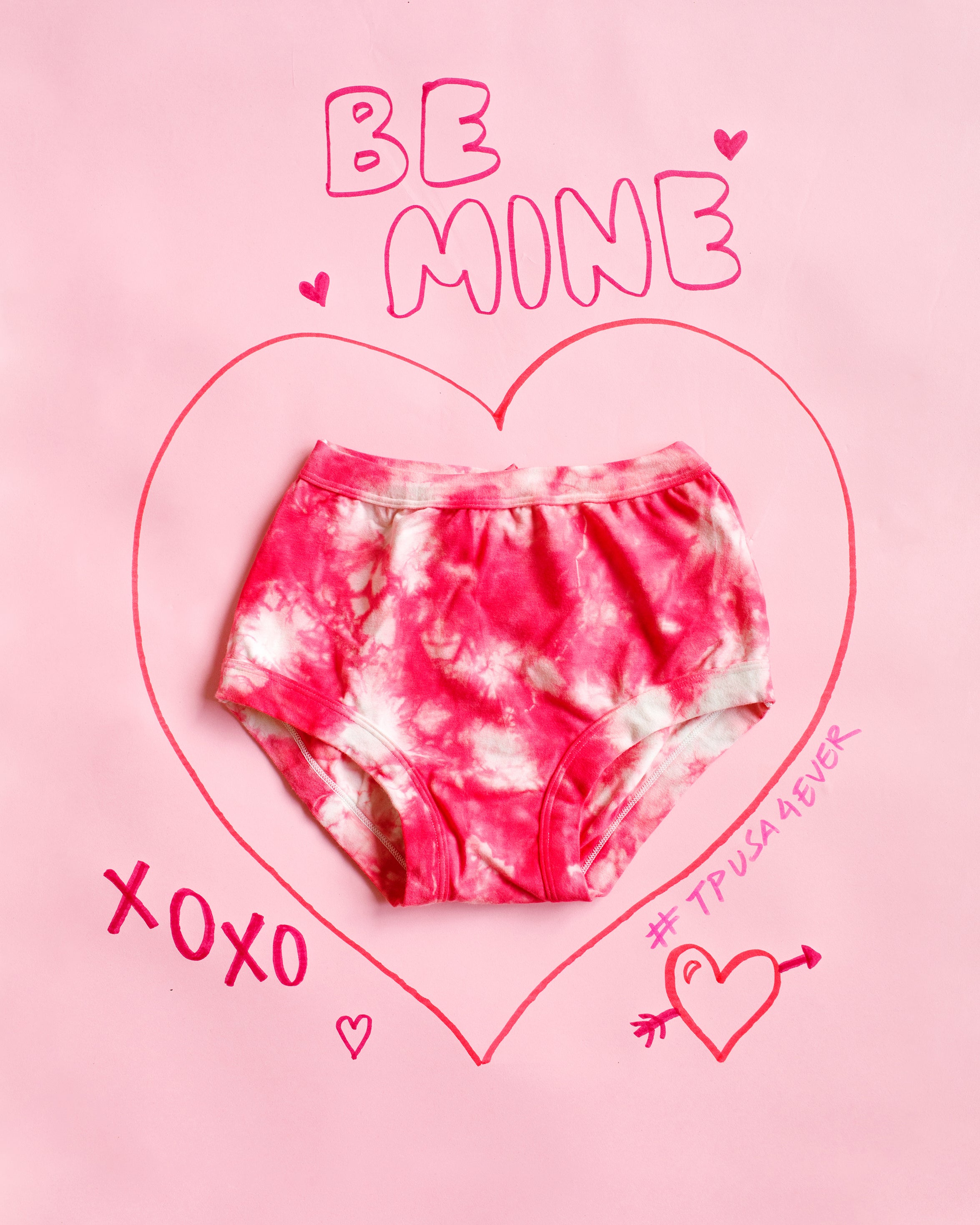 Flat lay of Thunderpants Original style underwear with red and white scrunch dye on a pink background with writing on it.