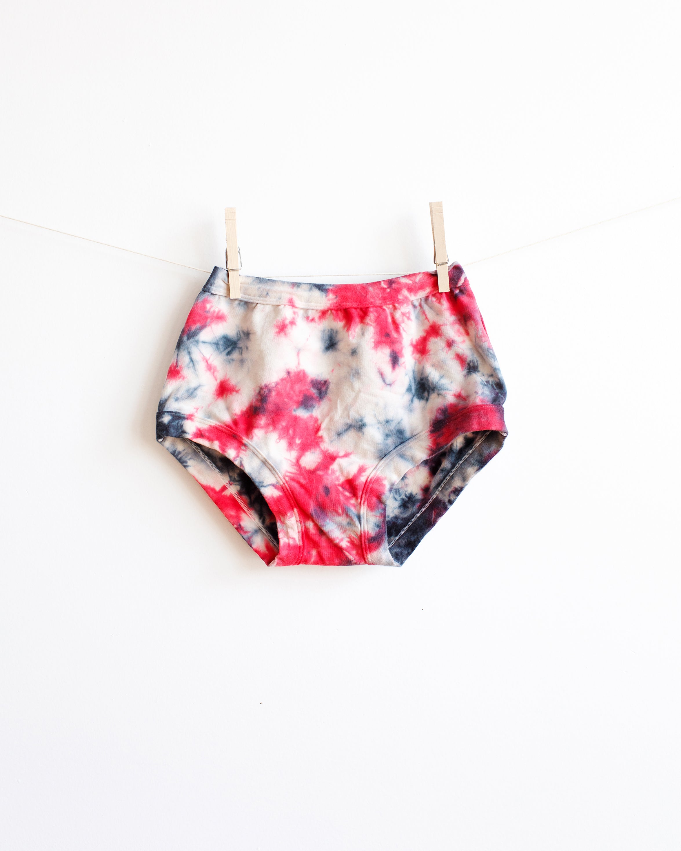 Thunderpants Original style underwear in black, red, and white scrunch dye hanging on a white background.